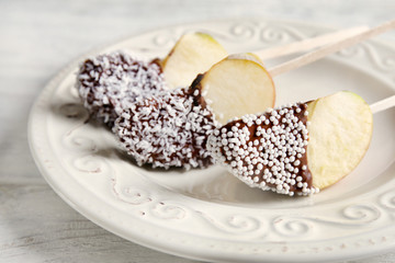 Plate with candied apple wedges on sticks