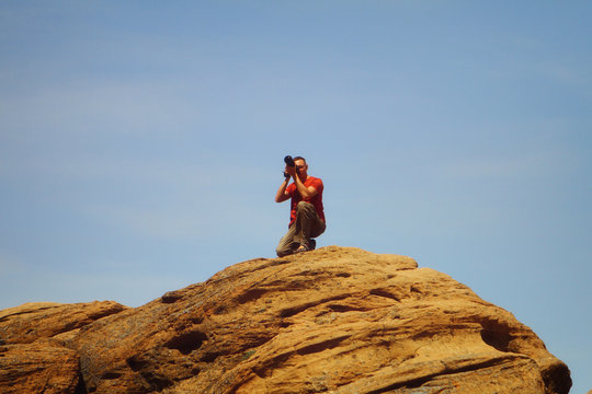 Professional male photographer takes photos on the mountain © Dancing Man