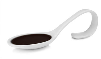 Spoon with delicious soy sauce isolated on white