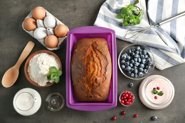 Hot yogurt cake in silicone baking dish with ingredients on table