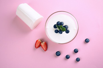 Delicious homemade yogurt with berries on pink background