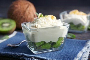 Coconut cream with kiwi slices in bowl on table