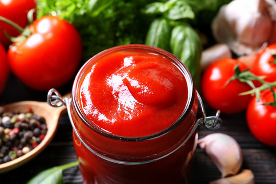 Ketchup in glass jar and ingredients, closeup