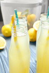 Delicious lemon juice in bottles on wooden table