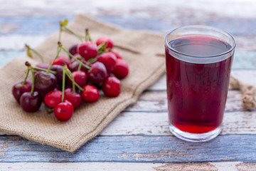 Cherry juice with cherries on turquoise vintage table