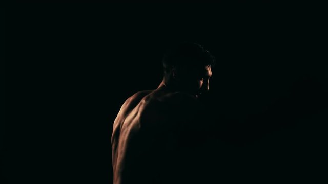 Boxer training in a gym, dramatic lighting. Slow motion