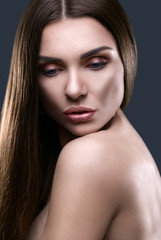 Fototapeta premium Portrait of beautiful woman with glistening hair in studio