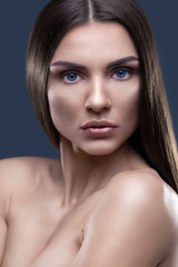 Fototapeta premium Portrait of beautiful woman with glistening hair in studio