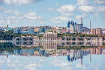 Naklejka premium Dolmabahce palace against coastal cityscape with modern buildings under cloudy sky istanbul city