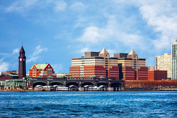 Hoboken, New Jersey waterfront and skyline viewed from the Hudson River. The historic Lackawanna train terminal, built 1907, is seen in the foreground. - obrazy, fototapety, plakaty