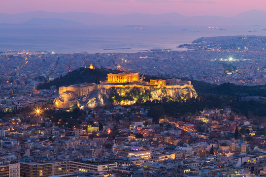cityscape of Athens with illuminated Acropolis hill, Pathenon and sea at night, Greece
