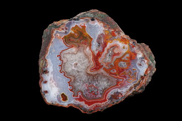 A cross section of the eyelet agate stone. Center filled with crystals of quartz. Multicolored silica bands colored with metal oxides are visible. Origin: Asni, Atlas Mountains, Morocco.