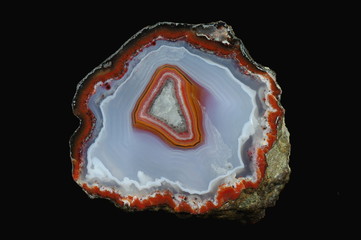 A cross section of the agate stone. Colorful center against the background of gray-blue and white chalcedony. Origin: Asni, Atlas Mountains, Morocco.