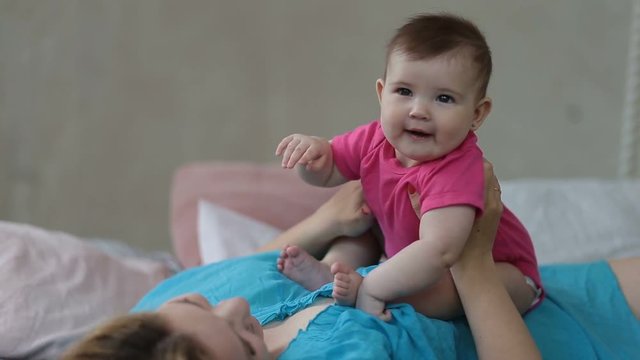 Portrait of excited baby infant laughing in bed