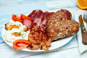 Breakfast with bacon, eggs and buns