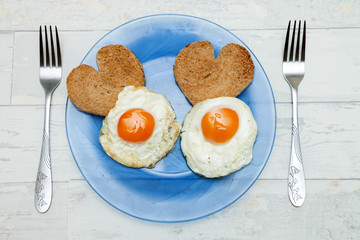 Fried eggs with toast in heart shape