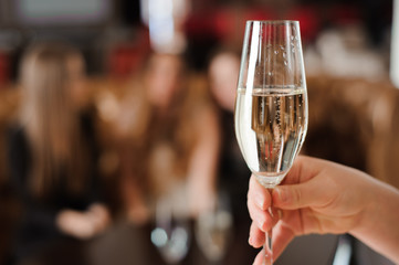 glass of champagne on the background of friends at a party