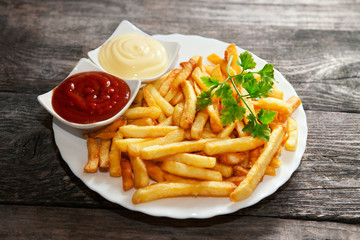 French fries with tomato sauce, mayonnaise and parsley