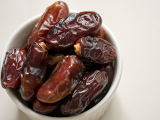 Dates fruit in a plate on wooden