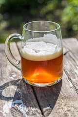 local craft brew in beer mug outside on wood table in sunshine