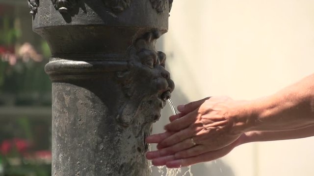 Well in street of Venice, man washing his hands in slow motion