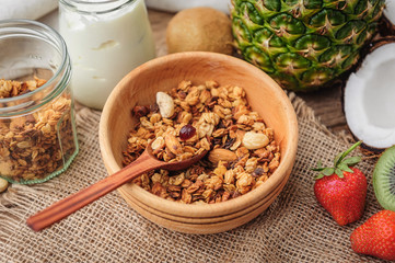 Granola with Greek yoghurt and fruit on a wooden background in a rustic style