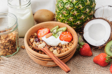 Granola with Greek yoghurt and fruit on a wooden background in a rustic style