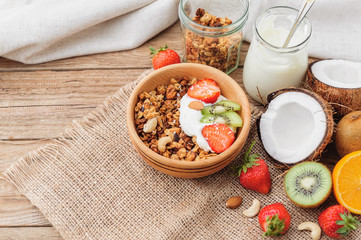 Granola with Greek yoghurt and fruit on a wooden background in a rustic style