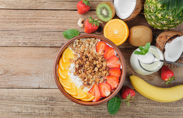 Granola with Greek yoghurt and fruit on a wooden background in a rustic style