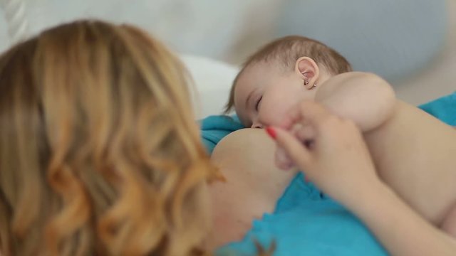 Adorable naked infant child breastfeeding