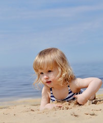 Little girl playing at the beach in sunny day