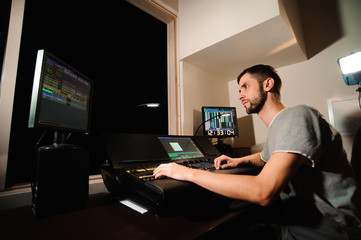 A lighting engineer works with lights technicians control on the concert show. Professional light mixer, mixing console. Equipment for concerts.
