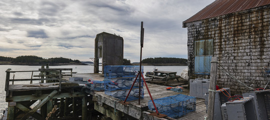 Fishing docks, and piers on Deer Island, one of the Fundy Bay Islands in Canada.  Old buildings, lobster traps and buoys fill the piers and docks.