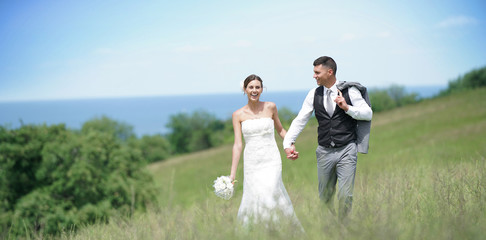 Bride and groom walking on hill
