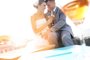 Bride and groom cheering with cocktails