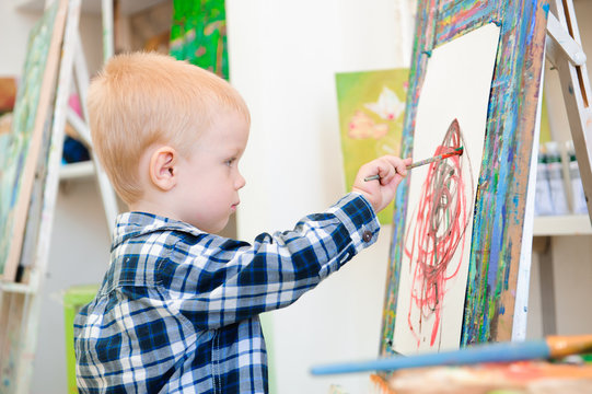 a child draws a picture paints on art lesson