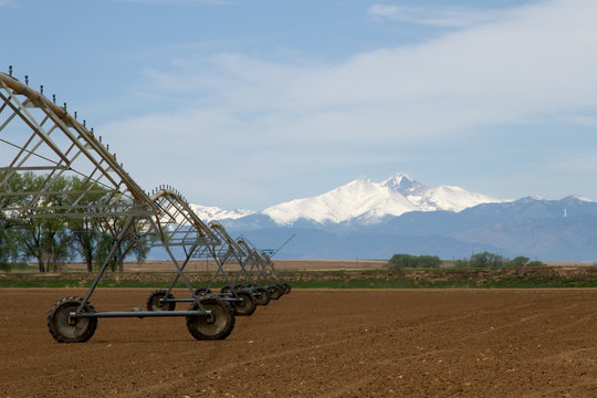 Pivot Irrigation System in a farming field with Longs Peak Mountain in the background