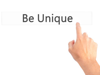 Be Unique - Hand pressing a button on blurred background concept on visual screen.