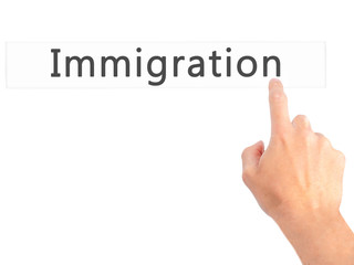 Immigration - Hand pressing a button on blurred background concept on visual screen.