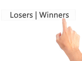 Winners  Losers - Hand pressing a button on blurred background concept on visual screen.