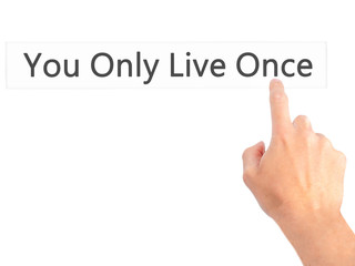 You Only Live Once - Hand pressing a button on blurred background concept on visual screen.