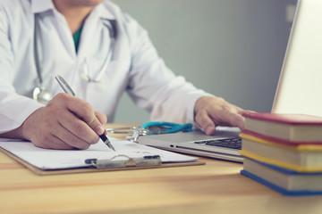 Male medicine doctor hand holding silver pen writing something on clipboard closeup. Medical care, insurance, prescription, paper work or career concept. Physician ready to examine patient and help - obrazy, fototapety, plakaty