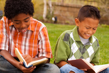 Happy young kids smiling and reading.