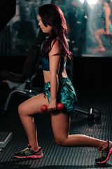 Fototapeta na wymiar Young woman doing exercises at the gym. Concept of healthy life