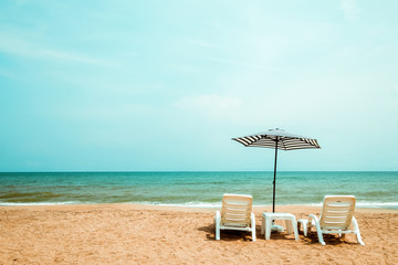 Fototapeta na wymiar Couple beach chair on tropical beach. vintage color tone effect