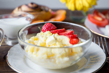 Breakfast table served with corn porridge, fried egg and flower