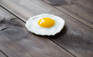 round shaped fried egg for healthy breakfast on dark wooden backgrond