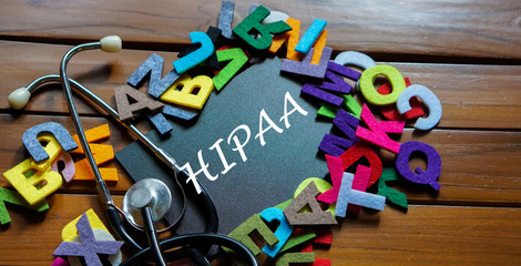 Black board written with " HIPAA " and stethoscope on wooden back ground.Image with selective focus.Medical and health care concept.