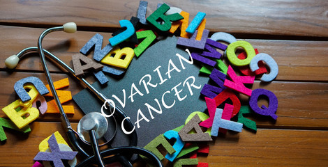 Black board written with " OVARIAN CANCER " and stethoscope on wooden back ground.Image with selective focus.Medical and health care concept.