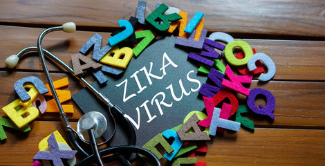 Black board written with " ZIKA VIRUS " and stethoscope on wooden back ground.Image with selective focus.Medical and health care concept.